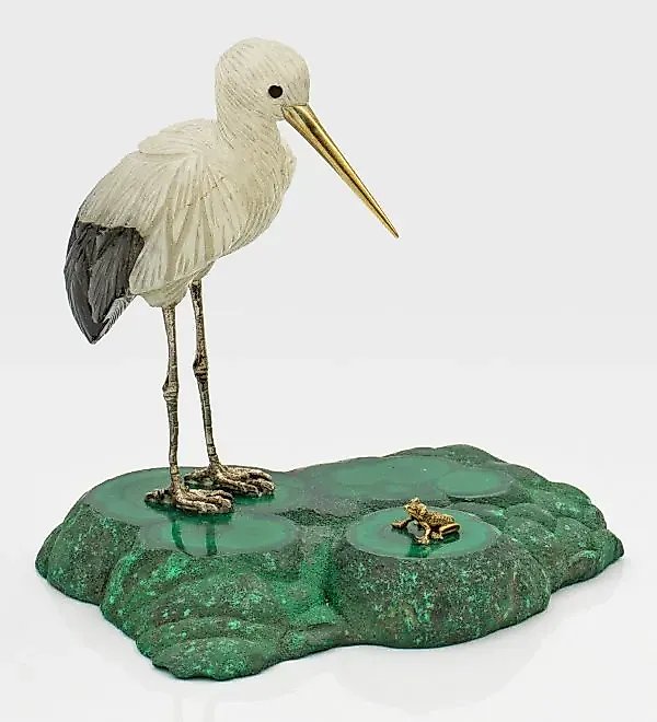 A stork with little legs and a gilded silver beak