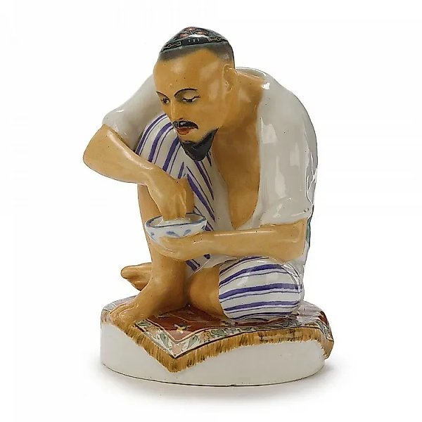 FIGURINE OF A SITTING UZBEK MAN, SOVIET PORCELAIN, LENINGRAD LOMONOSOV PORCELAIN FACTORY, 1930s