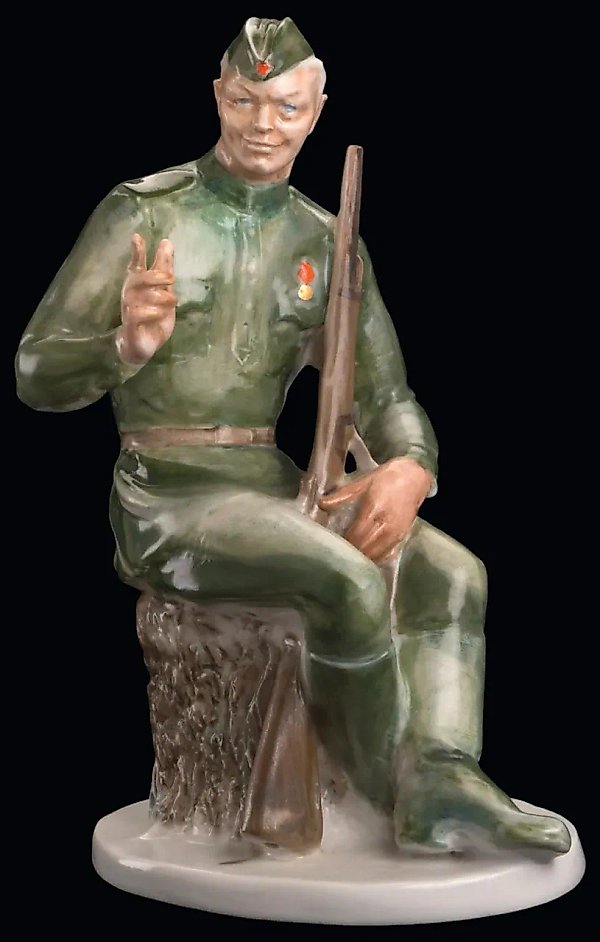 SOVIET PORCELAIN FIGURINE OF VASILY TERKIN IN THE FORM OF A SEATED YOUNG SOLDIER, DESIGNED BY ALEXEY GEORGIEVICH SOTNIKOV, DULEVO PORCELAIN FACTORY, 1948.