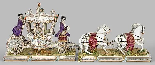 A large magnificent rococo-style carriage with four horses harnessed.