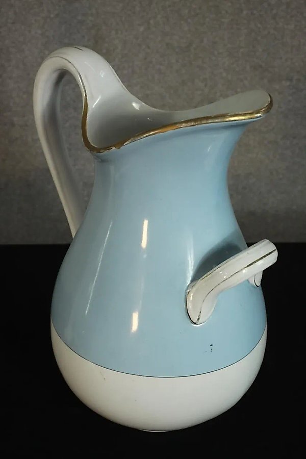 Kuznetsov porcelain jug with a gold rim and light blue coloring.