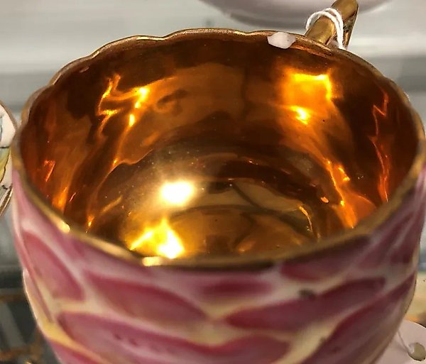 A porcelain pair of cups and saucers by Kuznetsov with painting and gold details