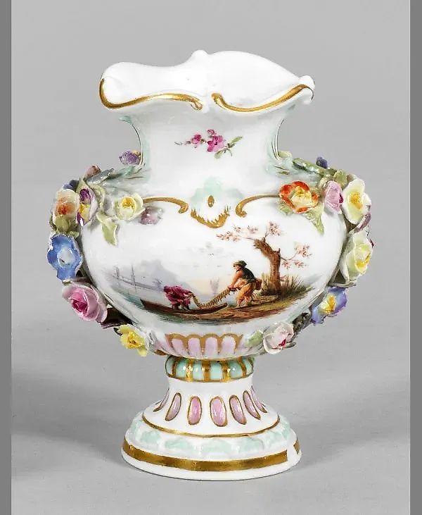 A miniature vase with a plastic floral decoration.