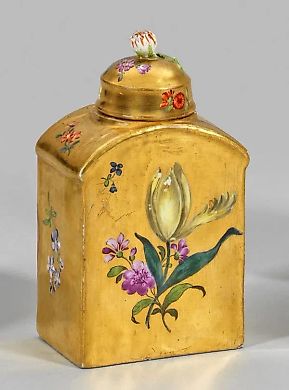 Golden tea box with a floral pattern.