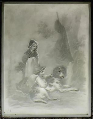 A lead frame with a porcelain lithograph depicting two children with a dog