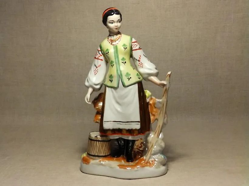 A girl by the wattle fence with a yoke