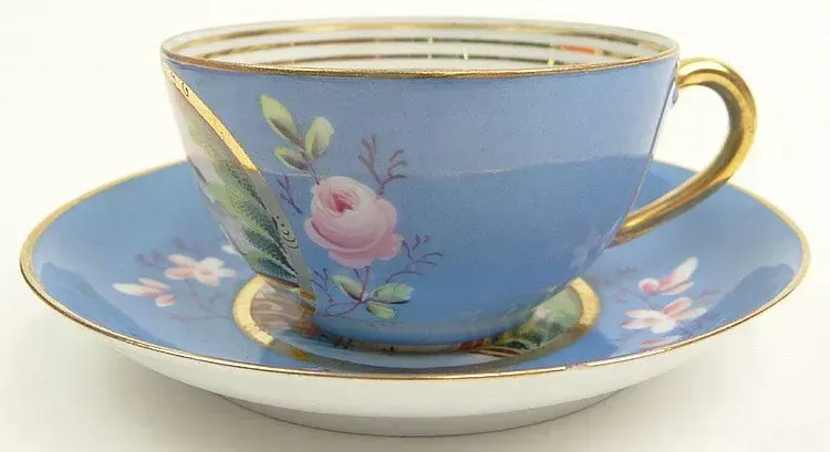 19/20th Century Russian Kuznetsov Porcelain Factory Painted and Gilt Porcelain Tea Cup and Saucer with Painted Country Cottage Scene. Signed and with Imperial Warrant Mark. Good Condition or Better. Measures 2 Inches Tall and 3-1/2 Inches Diameter.