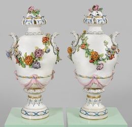A pair of monumental lidded vases with sculpted floral decoration.