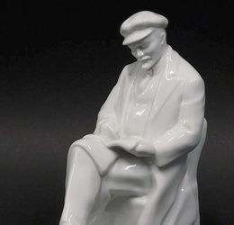 A Dulevo style undecorated porcelain figure of Lenin, seated reading, unmarked, 22cm high.