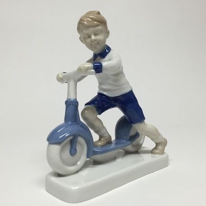 The boy on a scooter.