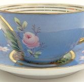 19/20th Century Russian Kuznetsov Porcelain Factory Painted and Gilt Porcelain Tea Cup and Saucer with Painted Country Cottage Scene. Signed and with Imperial Warrant Mark. Good Condition or Better. Measures 2 Inches Tall and 3-1/2 Inches Diameter.