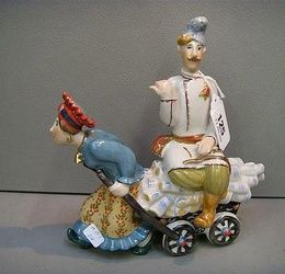 A Kiev porcelain group model of a woman pulling a