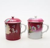 Two near pairs of Russian hand decorated porcelain mugs and covers