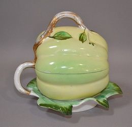 KUZNET SOV MELON FORM LIDDED CONTAINER Imperial Russian Kuznet Sov porcelain covered bowl. Melon form with attached leaf form underplate. 6''H. 6''L. 5 1/2''W. Mark, Kuznet Sov 19th.c.mark. Condition, age appropriate wear. (wear to gilt).
