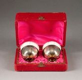 A PAIR OF PORCELAIN CUPS WITH SILVER FOOT WITHIN...