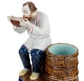 A RUSSIAN PORCELAIN FIGURE OF A PEASANT DRINKING FROM A KOVSH, KUZNETSOV PORCELAIN FACTORY, TVER, LATE 19TH CENTURY