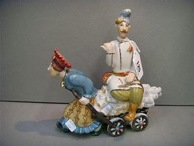 A Kiev porcelain group model of a woman pulling a