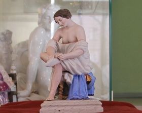 The statue depicts a girl putting on stockings in the bathroom.