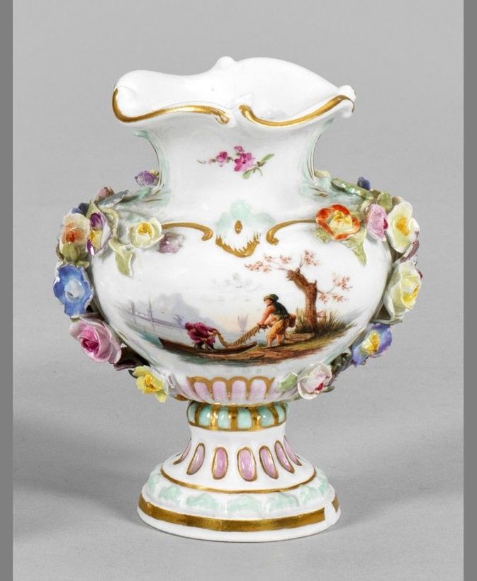 Миниатюрная ваза с пластиковым украшением из цветов.