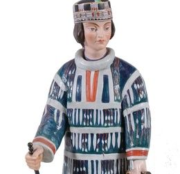 A Russian biscuit porcelain figure of a woman in native dress