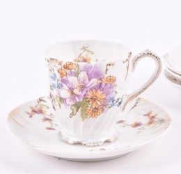 A pair of Imperial Russian Kuznetsov porcelain cups and saucers circa 1891-1917, the cups delicately