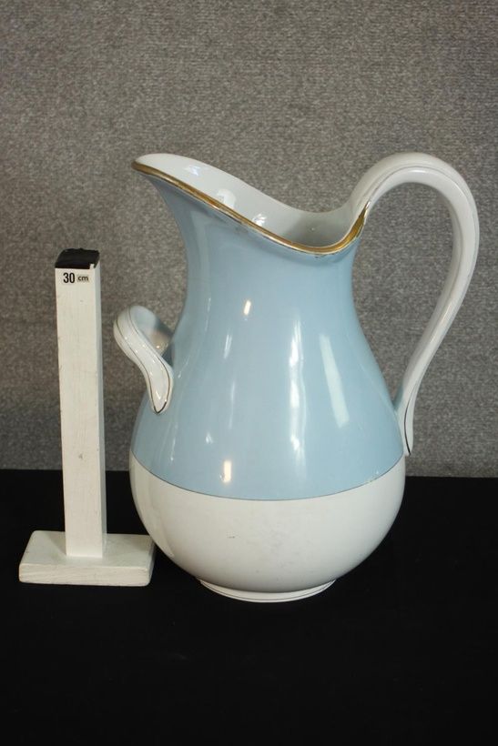 A Russian Kuznetsov porcelain wash jug, with a gilt rim, much of the body painted light blue. H.39